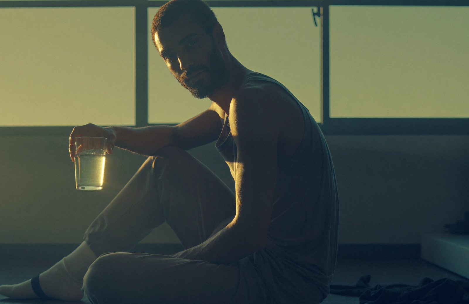 Athlete resting with water in morning light